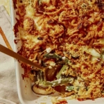 Close up on a green bean casserole with a serving taken out of it.