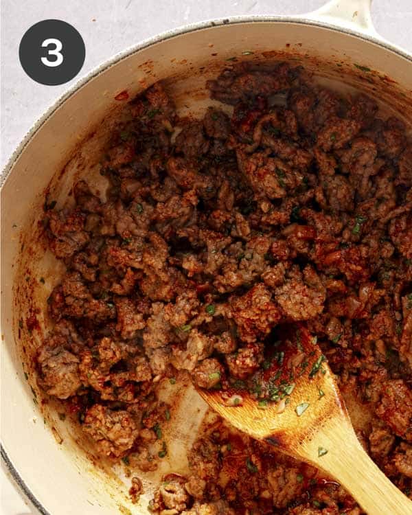 Meat and onions with tomato sauce cooking in a pot. 