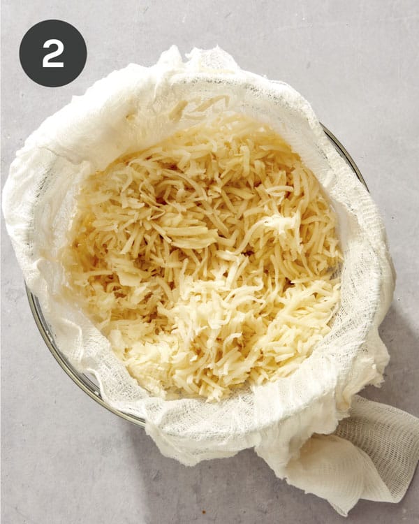 Shredded potatoes in cheesecloth with the liquid squeezed out.