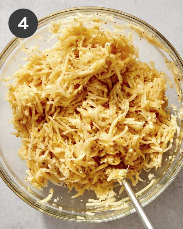 Freshly mixed potato latke ingredients in a bowl.
