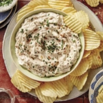 French onion dip in a bowl with chips on the side.