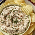 French onion dip in a bowl with chips on the side.