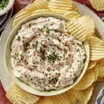 French onion dip in a bowl with chips on the side.