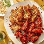 Korean fried chicken on a platter with garnishes on the side.