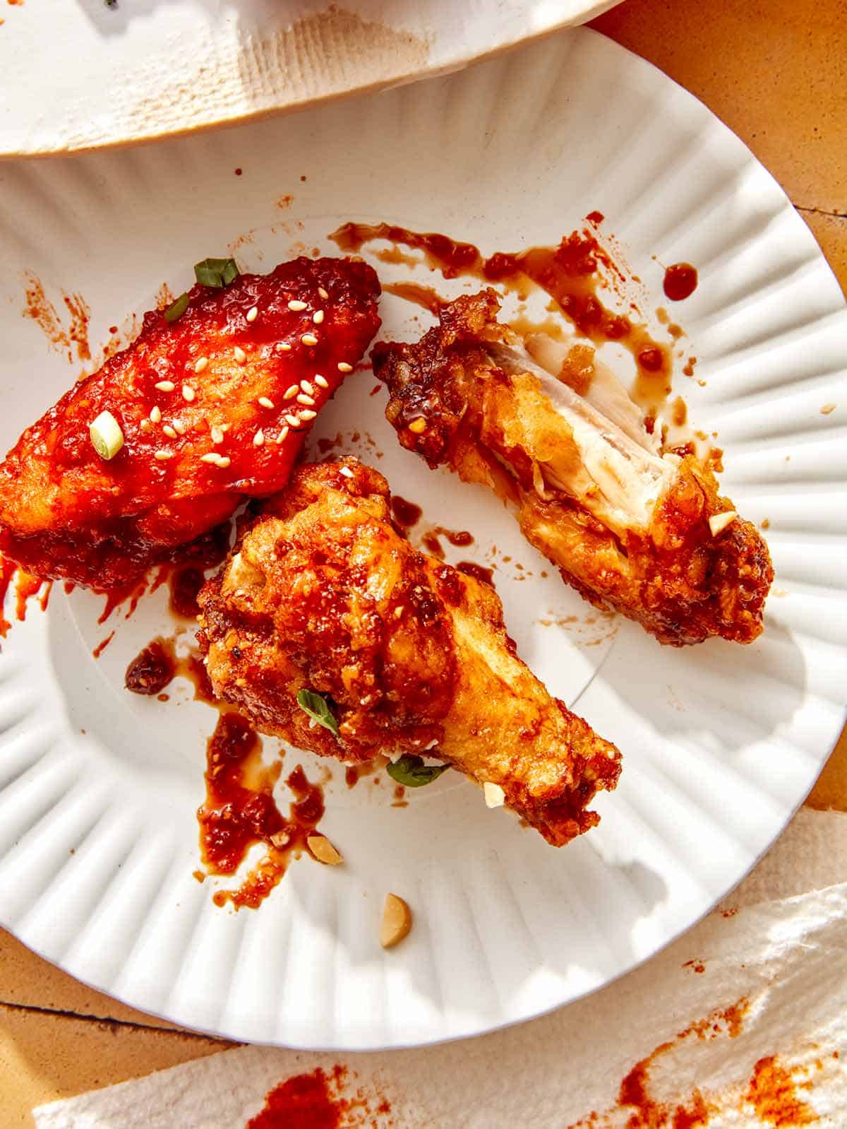 Korean fried chicken on a plate being eaten.