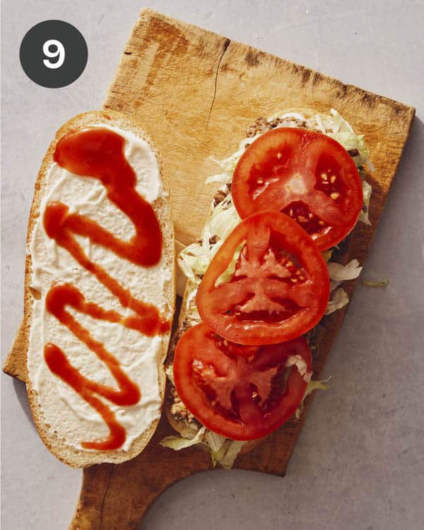A chopped cheese sandwich opened on a cutting board.