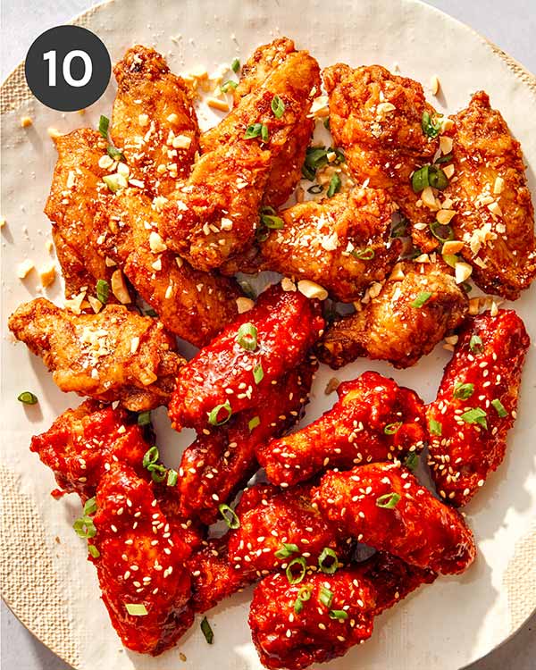 Korean fried chicken with garnishes on top. 