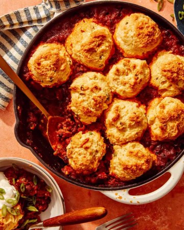 Chili Cornbread Casserole in a skillet with a scoop taken out.
