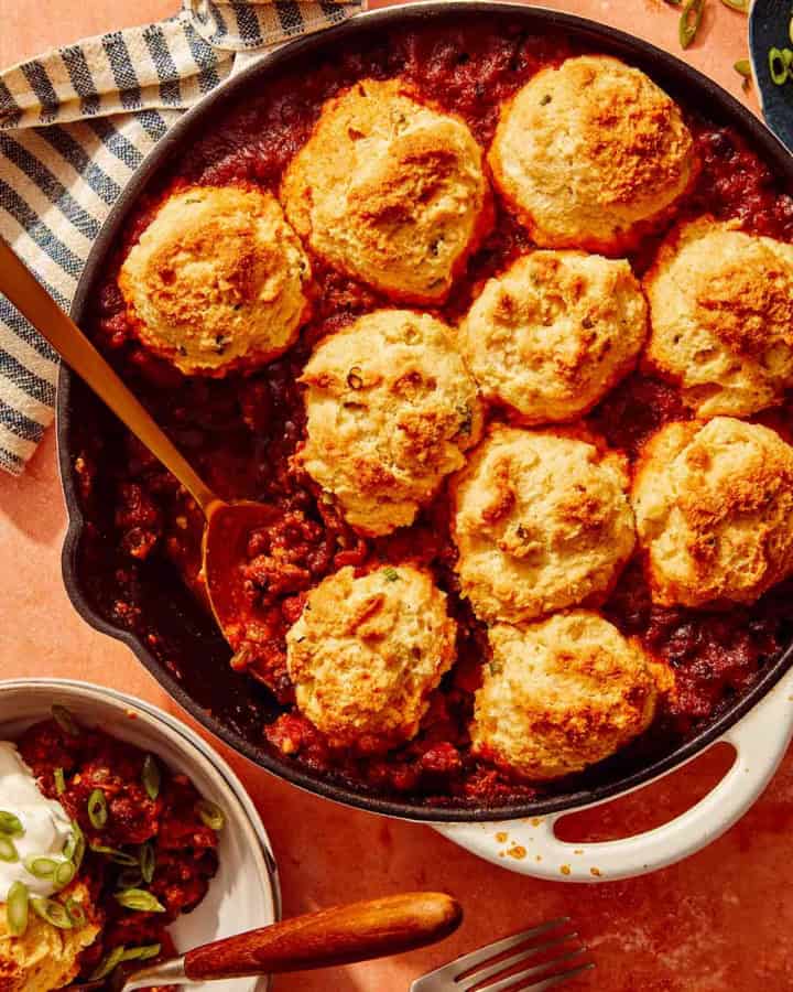Chili Cornbread Casserole in a skillet with a scoop taken out.