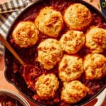 Chili Cornbread Casserole in a skillet with a scoop taken out.