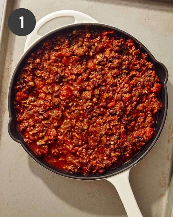 Chili in a skillet to be topped with biscuits.