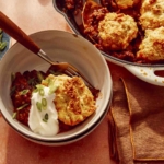 Chili cornbread casserole in a bowl with the skillet next to it.