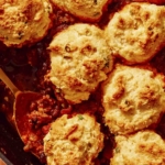 Chili Cornbread Casserole in a skillet with a scoop taken out.