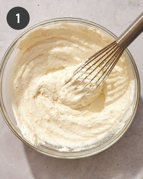 Ricotta mixture in a bowl with a whisk.