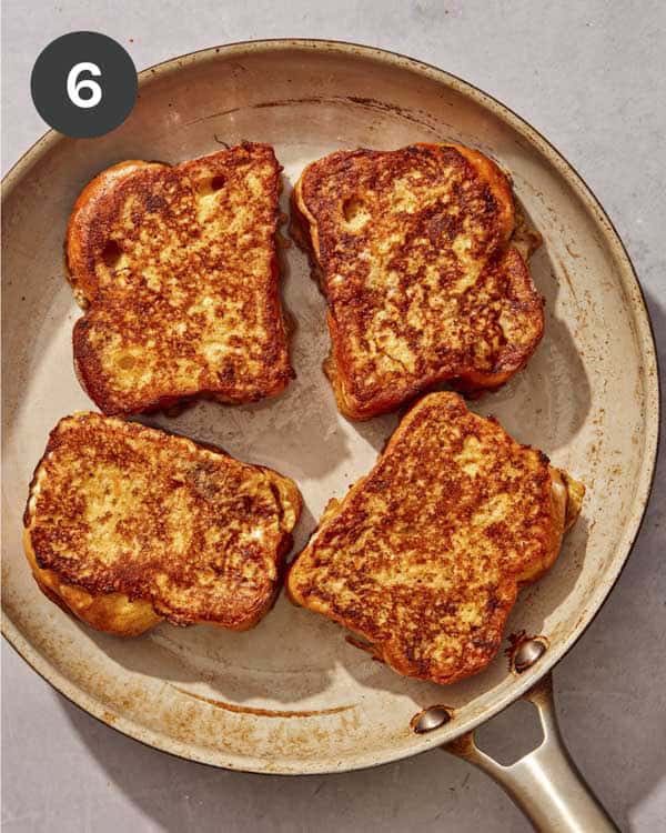 French toast slices in a skillet ready to go into the oven.
