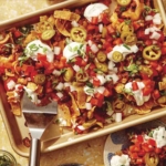 Frito pie being served onto plates.