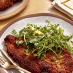 Chicken milanese recipe on a dinner plate.