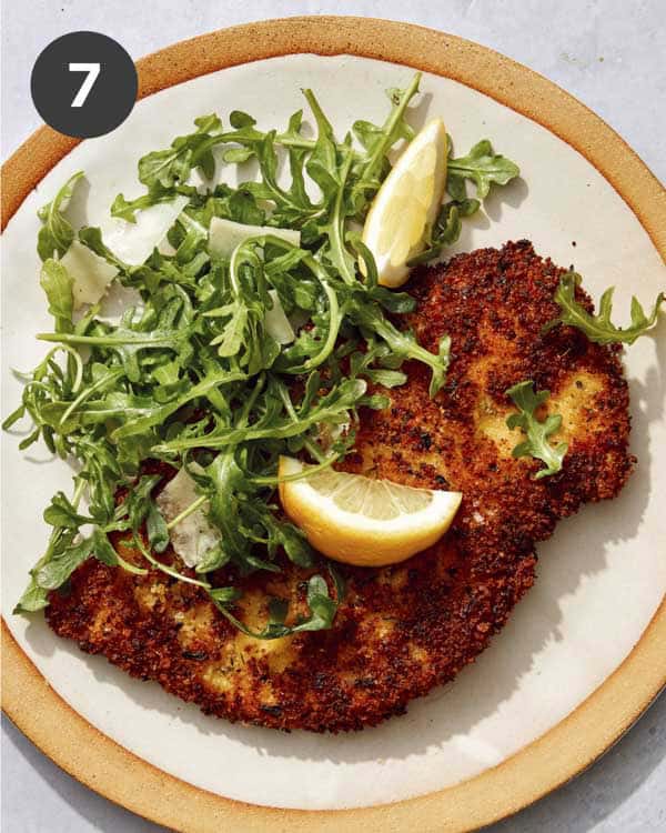 A plate of chicken milanese and a salad.