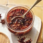 Chili crisp in a jar with a spoon in it.