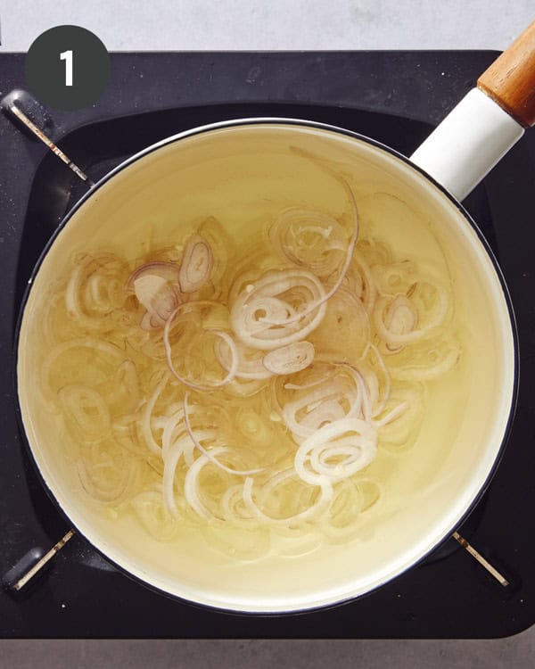 Shallot frying in a pot with oil.