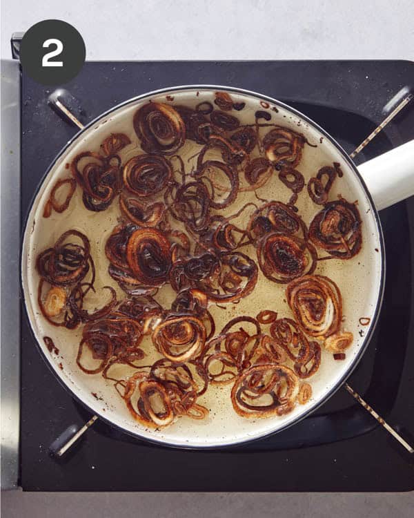 Shallots fried in a pot of oil.