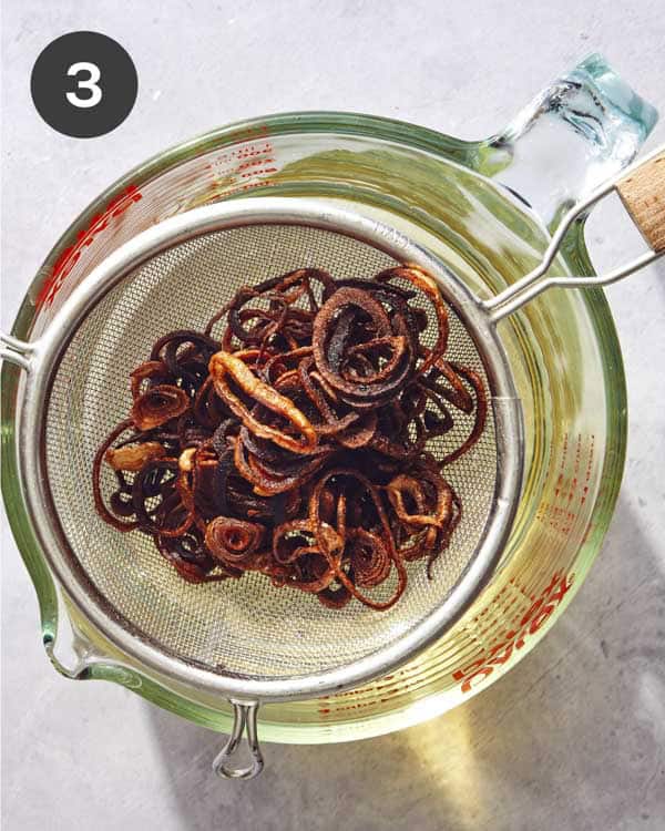 Fried shallots being drained.