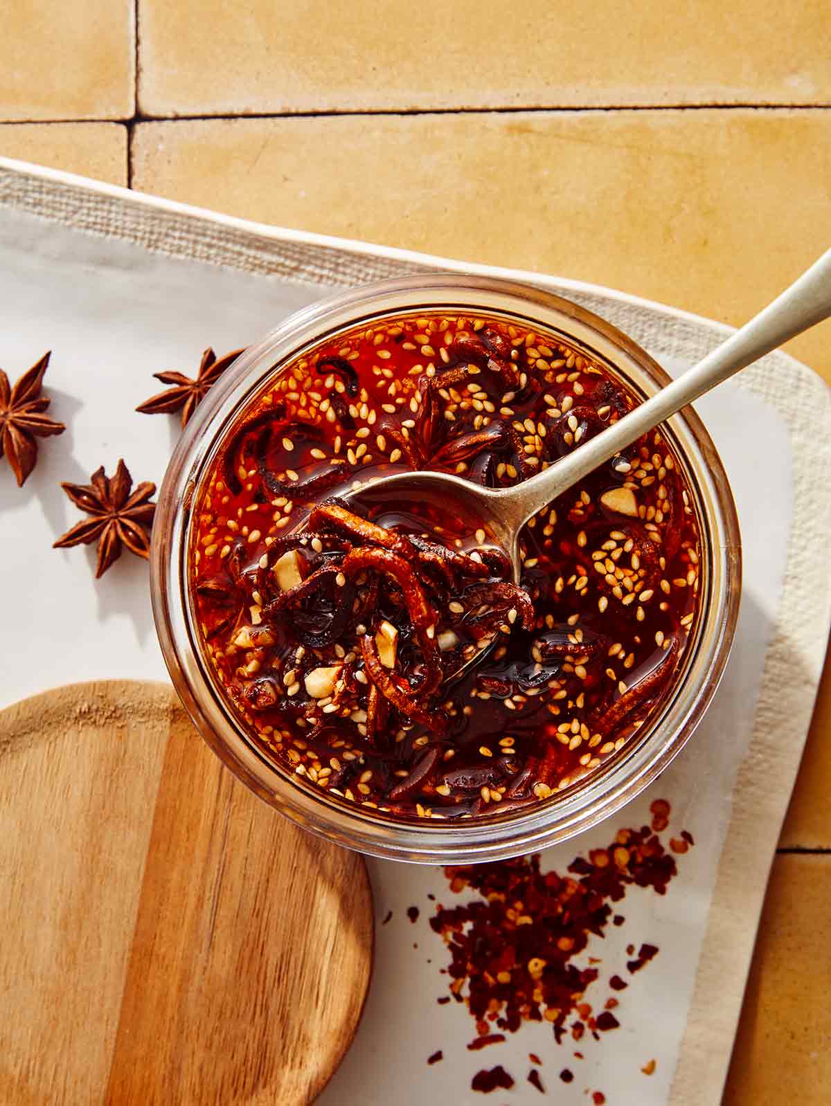 Chili crisp with a spoon taking some out of a jar.