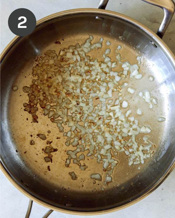 A pan of garlic cooking on a kitchen counter.