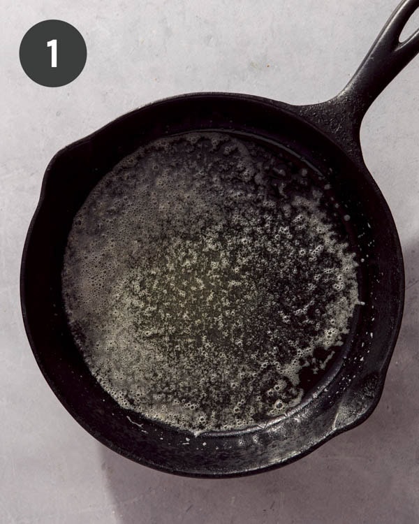 Butter melted in a cast iron skillet.