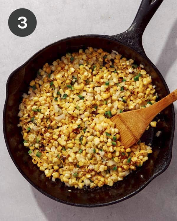 Corn cooking in a skillet with butter.