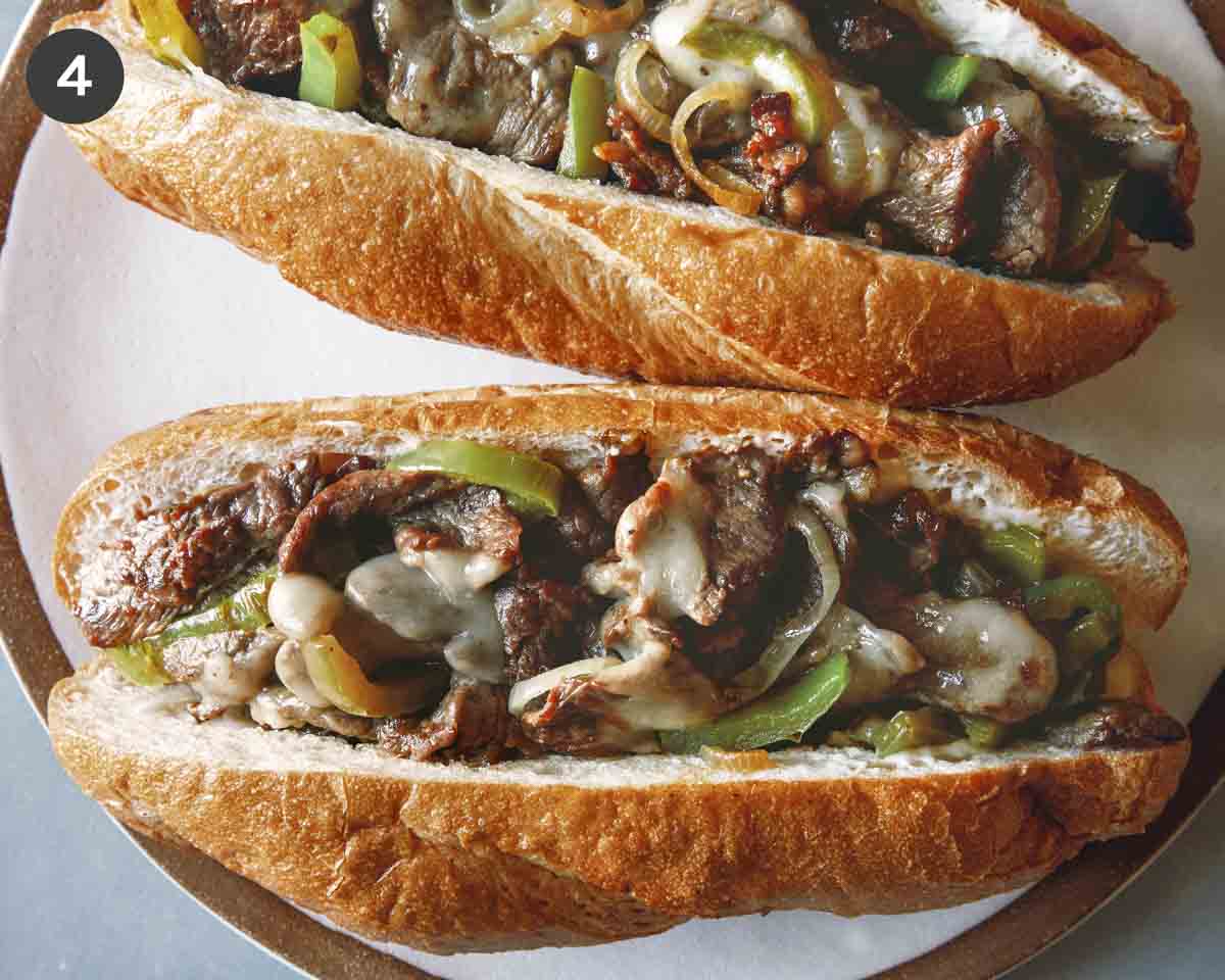 Two Philly Cheesesteak sandwiches on a plate.