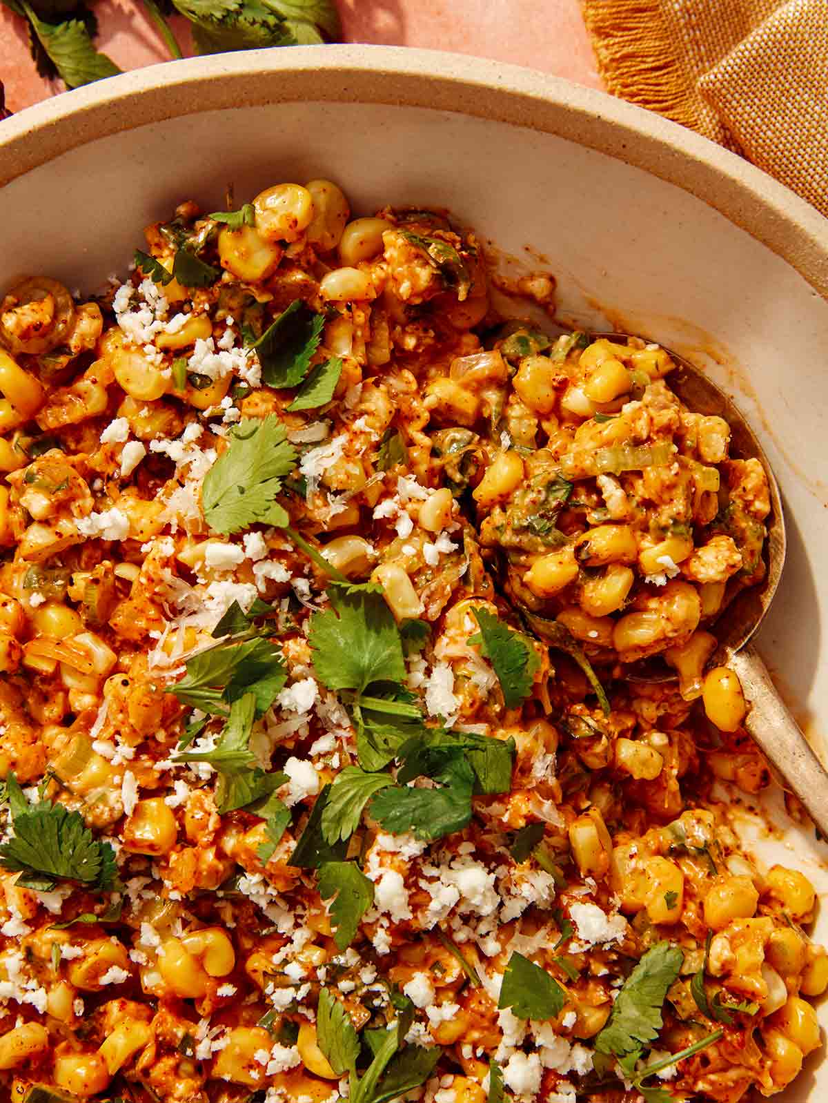 Mexican street corn salad in a bowl with a scoop taken out.