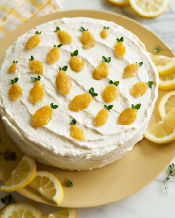 Whole lemon thyme cake garnished with lemon slices.