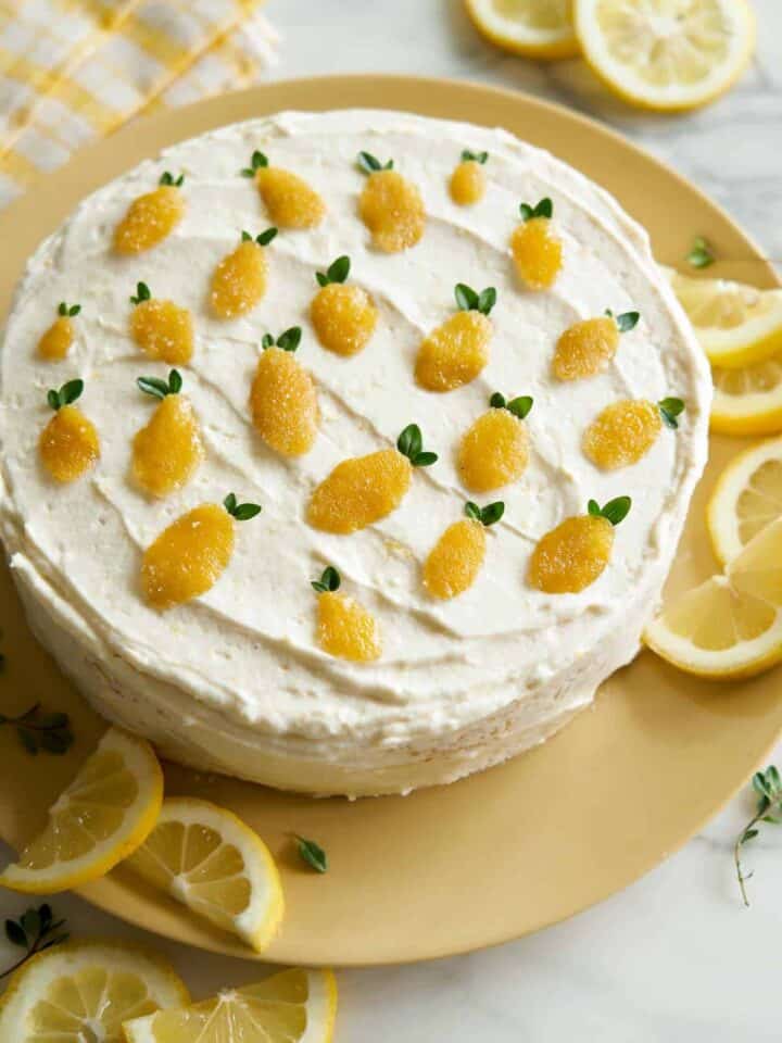 Whole lemon thyme cake garnished with lemon slices.