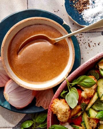 Balsamic Vinaigrette recipe in a bowl with a spoon with ingredients around it.