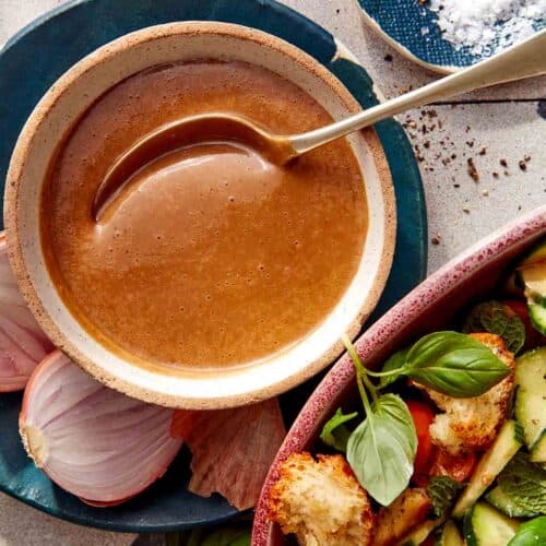 Balsamic Vinaigrette recipe in a bowl with a spoon with ingredients around it.