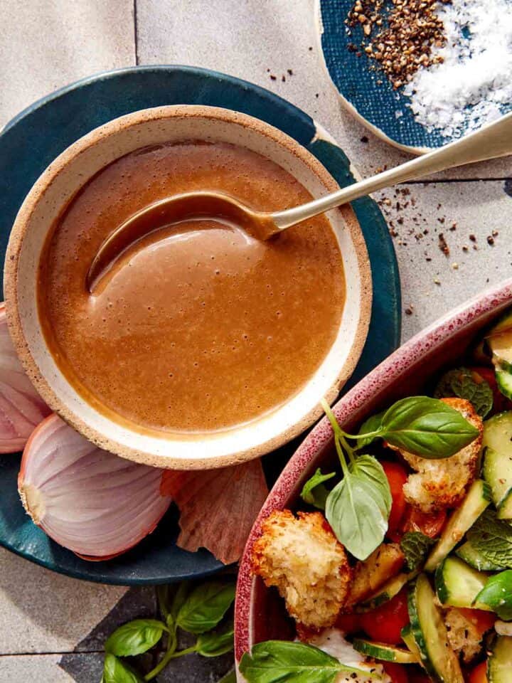 Balsamic Vinaigrette recipe in a bowl with a spoon with ingredients around it.