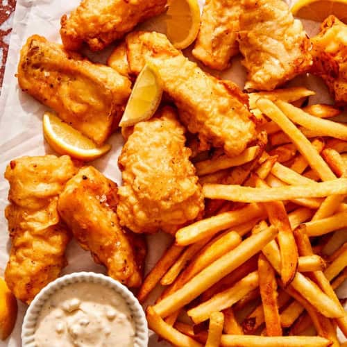 Beer battered fish with french fries and tartar sauce ready to be eaten.