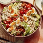 Cobb salad in a bowl ready to be tossed.