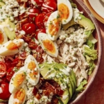 Cobb salad in a bowl ready to be tossed.