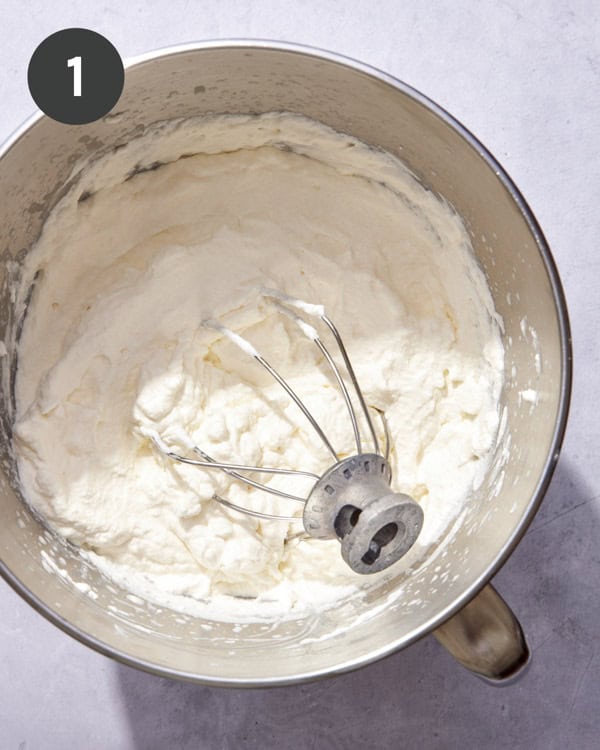 Whipping cream in a bowl with a whisk.