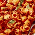 Spicy rigatoni in a bowl up close with a fork on the side.