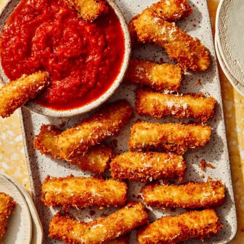 Fried zucchini on a platter being served to guests.
