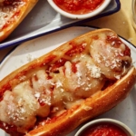 Close up on a plate with a meatball sub on it.