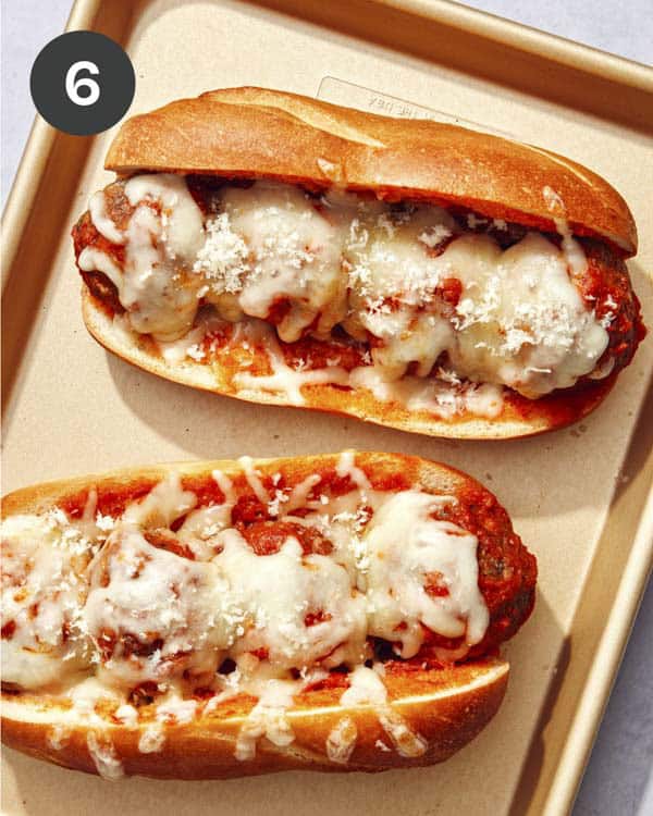 Meatball subs out of the oven with cheese melted on top of them.