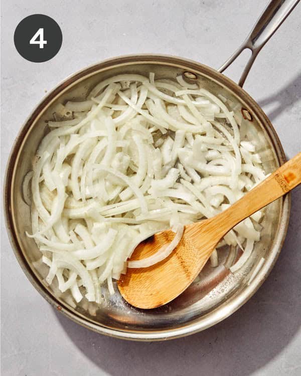 Onions being caramelized in a skillet.