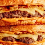 Patty melts on a cutting board.