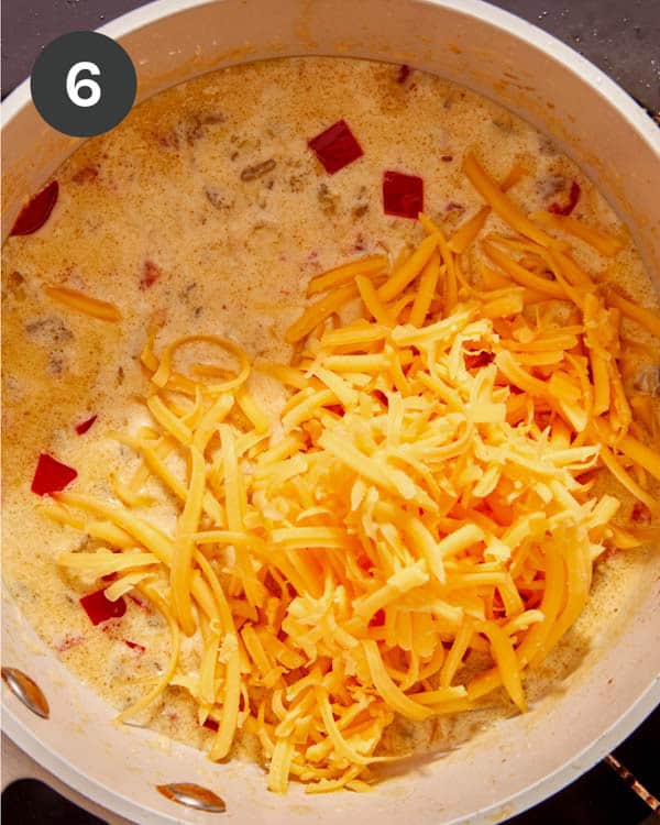 Cheese being added to a pot to make queso.