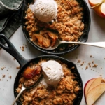 Apple crisps in cast iron skillets being eaten.