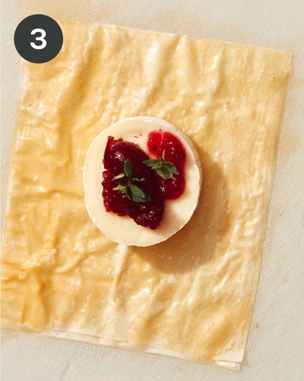 Phyllo squares with a brie wheel topped with cranberry sauce and thyme.